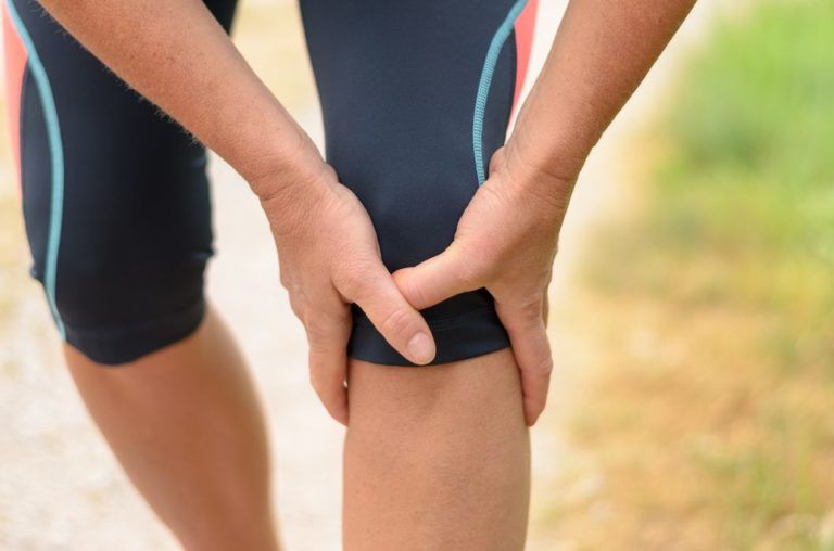 athlete holding knee in pain